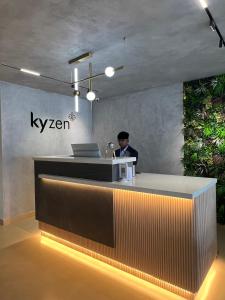 un hombre sentado en una recepción con un portátil en Hotel Kyzen Hi Tech City en Hyderabad