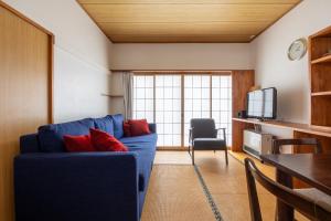 uma sala de estar com um sofá azul com almofadas vermelhas em Vaisala em Nozawa Onsen