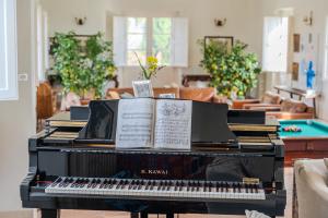 um piano com livros em cima em Tenuta di Tramonte Boutique Hotel em Lucca