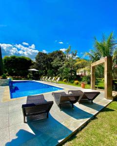 una piscina con un gruppo di sedie accanto ad essa di Casa Colonial San Alejo a Lemos