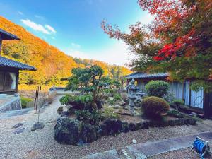 un jardín frente a una casa con árboles en 【1棟貸切】奈良公園から車で約12分　近隣ゴルフ場迄車で約8分　送迎車有り, 