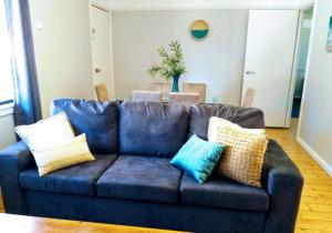 un sofá azul con almohadas en la sala de estar en Lake Hume Resort, en Lake Hume