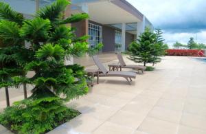 un patio con 2 sillas y un árbol frente a un edificio en Home Of Soleil At SM Wind Tagaytay, en Tagaytay