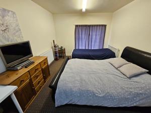 Schlafzimmer mit einem Bett und einem Flachbild-TV in der Unterkunft 2 bedroom apartment in Greater Manchester in Ashton under Lyne