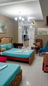 1 dormitorio con 2 camas y sala de estar en Home Of Soleil At SM Wind Tagaytay, en Tagaytay