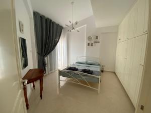 um quarto com uma cama, uma mesa e uma cadeira em Paradise Gardens 1 em Pafos