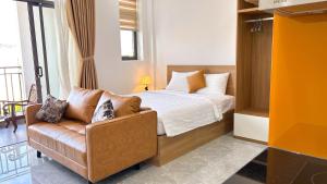 a bedroom with a bed and a couch and a window at Sea Flower Homestay in Quy Nhon +16 photos