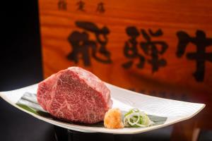 een stuk vlees op een bord met groenten bij Hotel Hotaka in Takayama