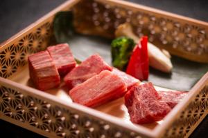 un piatto di carne e verdure in una scatola di Hotel Hotaka a Takayama