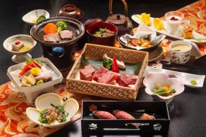 una mesa con muchos platos diferentes de comida en ella en Hotel Hotaka, en Takayama