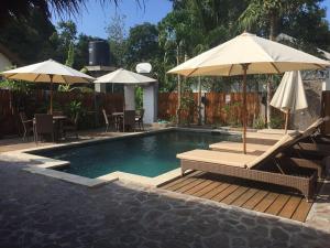 una piscina con sombrillas, mesas y sillas en Sol Villas Gili Air, en Gili Air