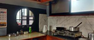 eine Küche mit Herd und Arbeitsplatte in der Unterkunft Halyo suite room Greentara Heritage Home by Tranquil home in Pātan + 22 Fotos