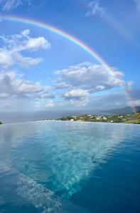 um arco-íris sobre um corpo de água com uma praia em Villa Indigo em Le Carbet