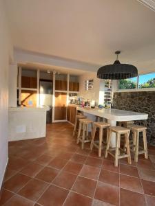 a kitchen with a table and some stools in it at Villa Indigo in Le Carbet