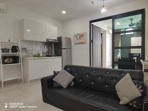 a living room with a black couch and a kitchen at H20 residence studio high floor in Petaling Jaya