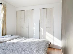 a white bedroom with a bed and white cabinets at Shinjuku#ookubo#kabukicho#New built 3beds room,3 toilets, 2 shower rooms#新宿中心#大久保#歌舞伎#地铁站步行2分#新建公寓3层3卧室3卫生间2浴室1客厅#高速无限制网络#智能马桶#干湿分离103 in Tokyo