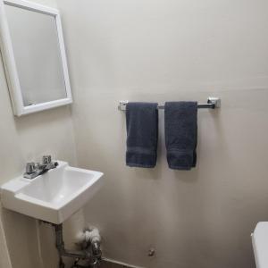 a bathroom with a sink and a mirror and blue towels at New York City GuestHouse in New York