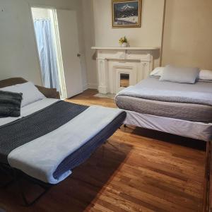 two beds in a room with a fireplace at New York City GuestHouse in New York