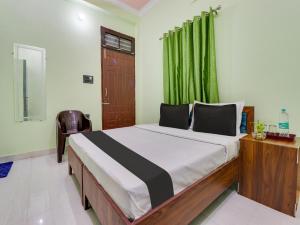 a bedroom with a bed with a green curtain at OYO Shri Radhe Guest House & Restaurant in Rishīkesh