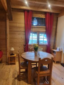 una sala da pranzo in legno con tavolo e sedie in legno di Le Nid des Cerfs a Essert-Romand