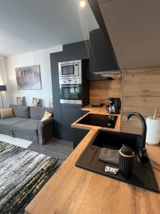 a kitchen and living room with a couch and a stove at Wake Up To Baltic Views AON Apartment Just Minutes From Beach in Gdańsk