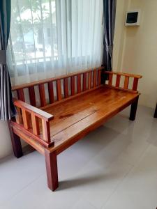 a wooden bench sitting in front of a window at Changsi Resort-Krabi in Krabi town