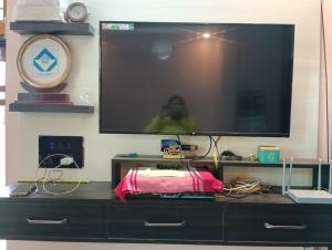telewizor z płaskim ekranem siedzący na komodzie w obiekcie Kshitijshomestay w mieście Lucknow
