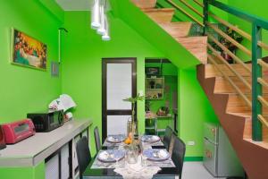a green dining room with a table and a green wall at Golden V Primera Unit B in Malolos