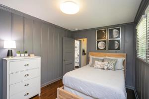 a bedroom with a bed and a white dresser at Hip Rustic Ranch Style Home in East Nashville in Nashville