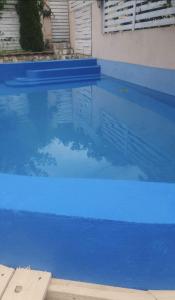 einem Pool mit blauem Wasser vor einem Gebäude in der Unterkunft Casa Petra in Sărata-Monteoru