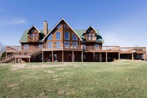 a large house with a green roof on a grass field at Secluded 18-Acres with Pool Hot Tub Pool Table in Fairview