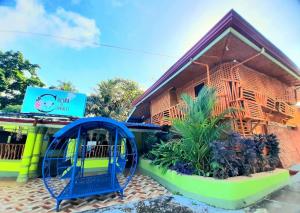 a small building with a blue arch in front of it at Villa Corrales Homestay in Mambajao