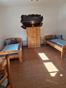 a room with three beds and a wooden floor at Pension NELE für Monteure NAHE Berlin in Mittenwalde
