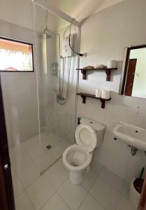 a bathroom with a shower and a toilet and a sink at Siargao Wakepark in General Luna