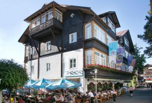 um grupo de pessoas sentadas fora de um edifício em Sascha's Kachelofen em Oberstdorf