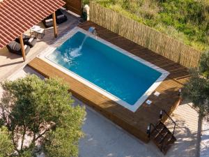 - une vue sur la piscine et sa terrasse en bois dans l'établissement Σπίτι με πισίνα δίπλα στο αεροδρόμιο., à Spáta