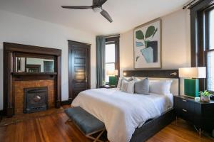a bedroom with a large bed and a fireplace at Historic Jewel in Hillsboro Village in Nashville