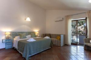 a bedroom with a bed and a couch and a window at Villa Nice Dream With Pool And Terrace - Happy Rentals in Neviano