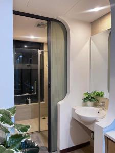 a bathroom with a white sink and a shower at YLY Homestay Hạ Long in Ha Long