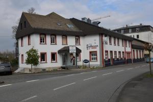 un bâtiment blanc sur le côté d'une rue dans l'établissement Hotel Paffhausen, à Wirges