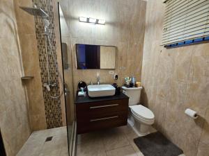 a bathroom with a toilet and a sink and a shower at Paradise Haven at Hamptons - -across from Ac Marriot Hotel in Kingston +6 photos
