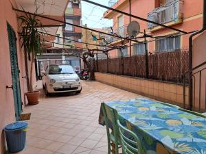una mesa en un balcón con un coche aparcado en una calle en Casa Rosa, en Finale Ligure