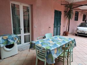 una mesa y sillas en un patio con lavadora en Casa Rosa, en Finale Ligure