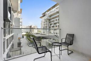 a balcony with two chairs and a table on it at Silkhaus Chic Studio Near Masdar City Park in Yas Island