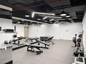 siłownia z kilkoma urządzeniami do ćwiczeń w pokoju w obiekcie Silkhaus High Floor in Millennium Executive Tower w Dubaju