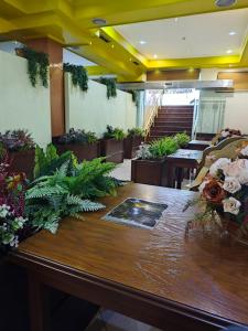 Pokój z dużym drewnianym stołem z kwiatami w obiekcie Hotel Artist w Tiranie