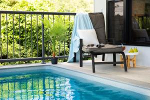 une chaise assise à côté d'une piscine dans l'établissement Serenity Seas - Airlie Beach, à Airlie Beach