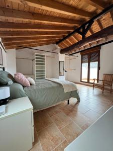 a bedroom with a bed in a room with wooden ceilings at Casa Rural El Alcázar - Cehegín in Cehegín