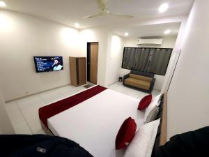 a bedroom with a bed and a tv in it at Hotel Near Me in Rajkot