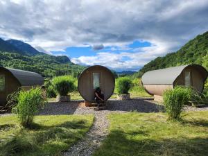 a woman is sitting in front of two circular houses at 4 Elements Bungalows & Apartments in Bled